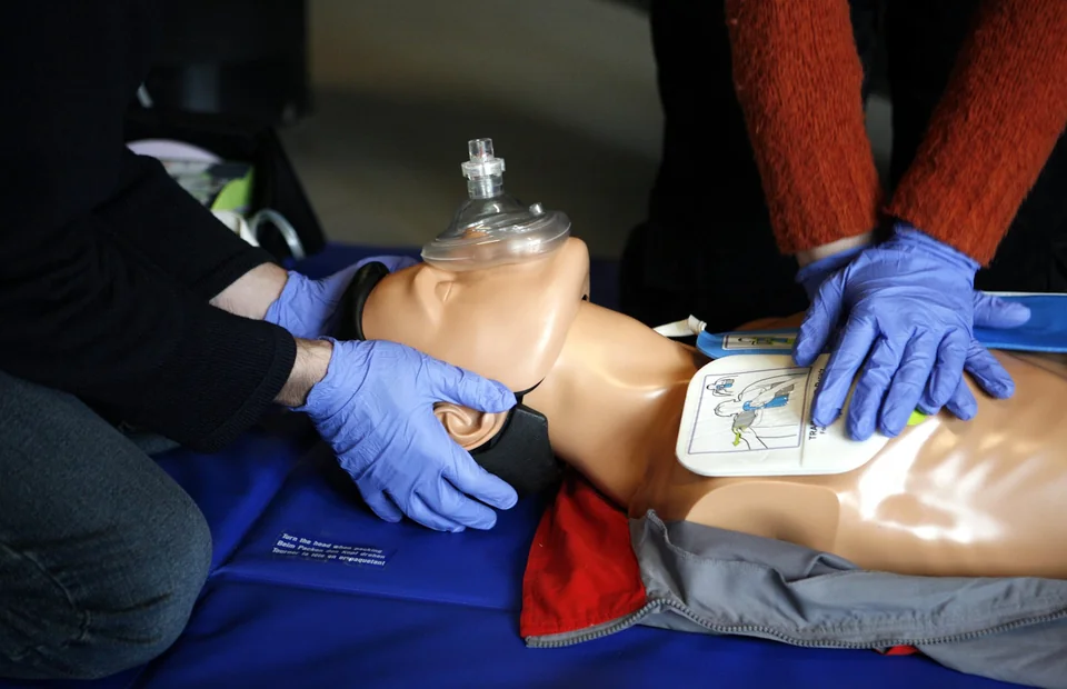 Participants practicing chest compressions and airway support on a CPR manikin