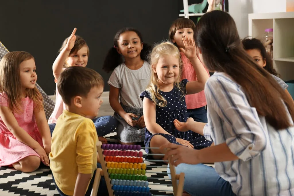 An educator leading a classroom activity with young children